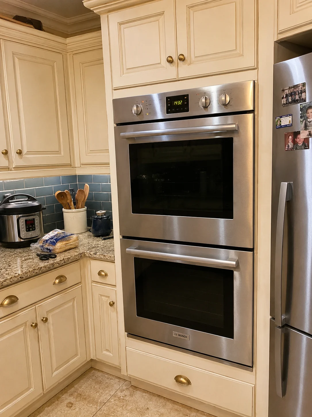 Oven repair technician working on built-in wall oven in Oakville home kitchen